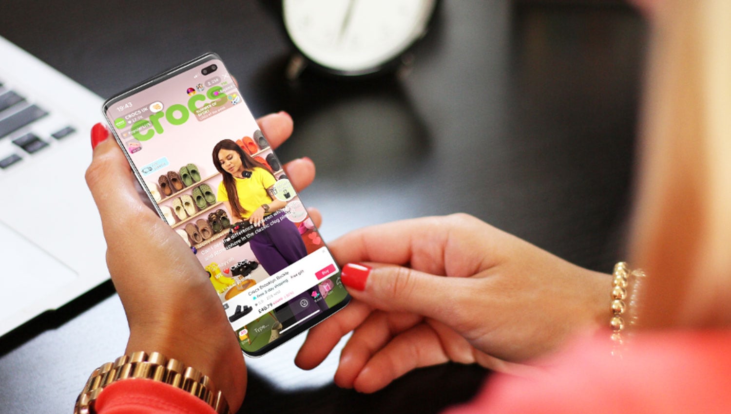 Woman using a smartphone to shop on TikTok with product display on screen.