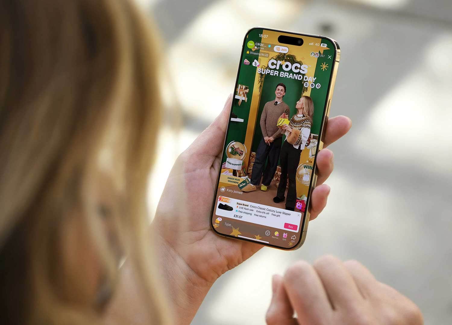 Person viewing Crocs UK Super Brand Day TikTok live shopping event on smartphone.