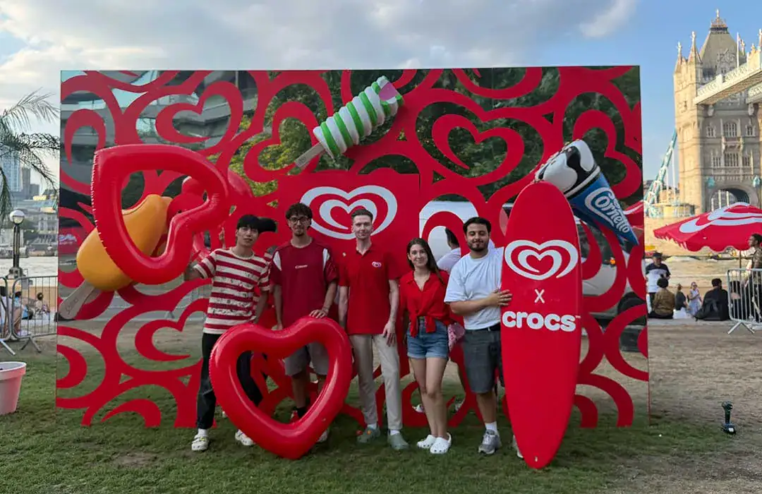 Group of people at a promotional event with heart-shaped decorations and ice cream.